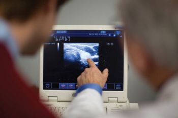 physicians examining ultrasound screen